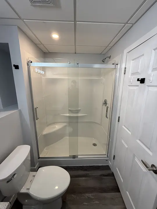 Modern bathroom with glass-enclosed shower and dark wood floor