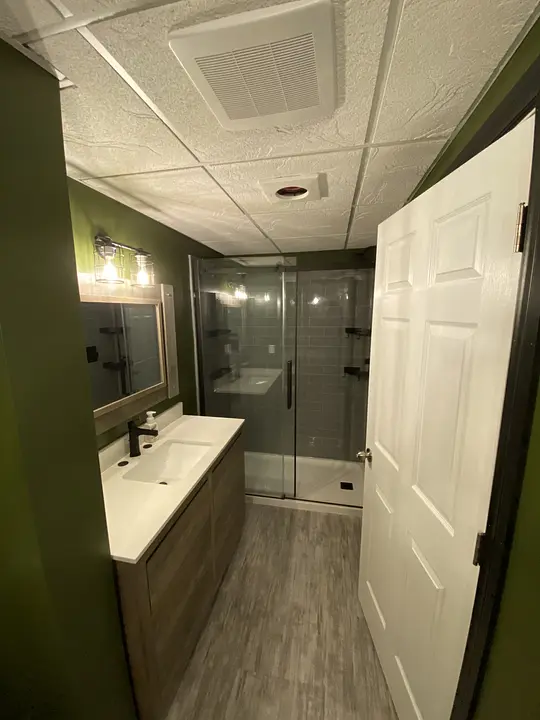 Modern renovated bathroom with glass shower and large mirror