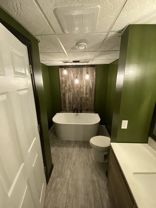 Modern bathroom with white bathtub and hanging lights