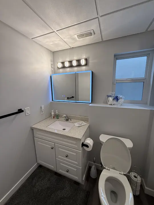 Modern bathroom with vanity and illuminated mirror